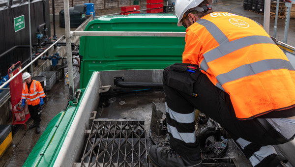Photo of operative working on top of Enva branded hazardous liquid waste vehicle.